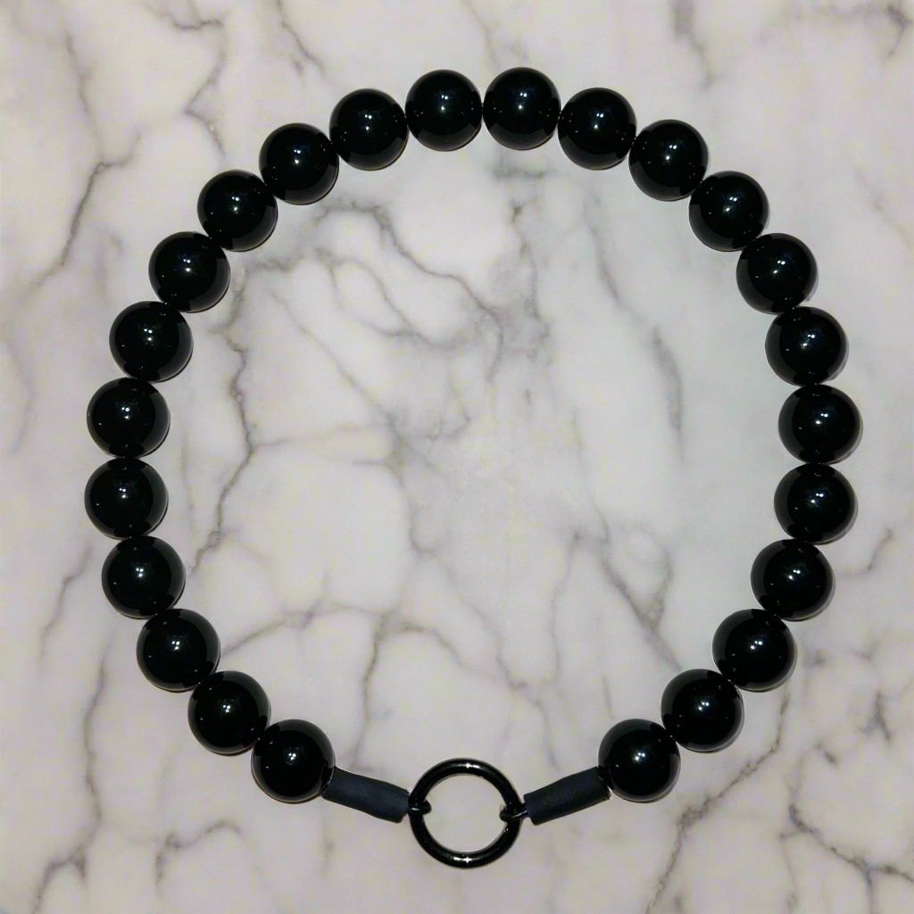 Black beaded bracelet on a marble background