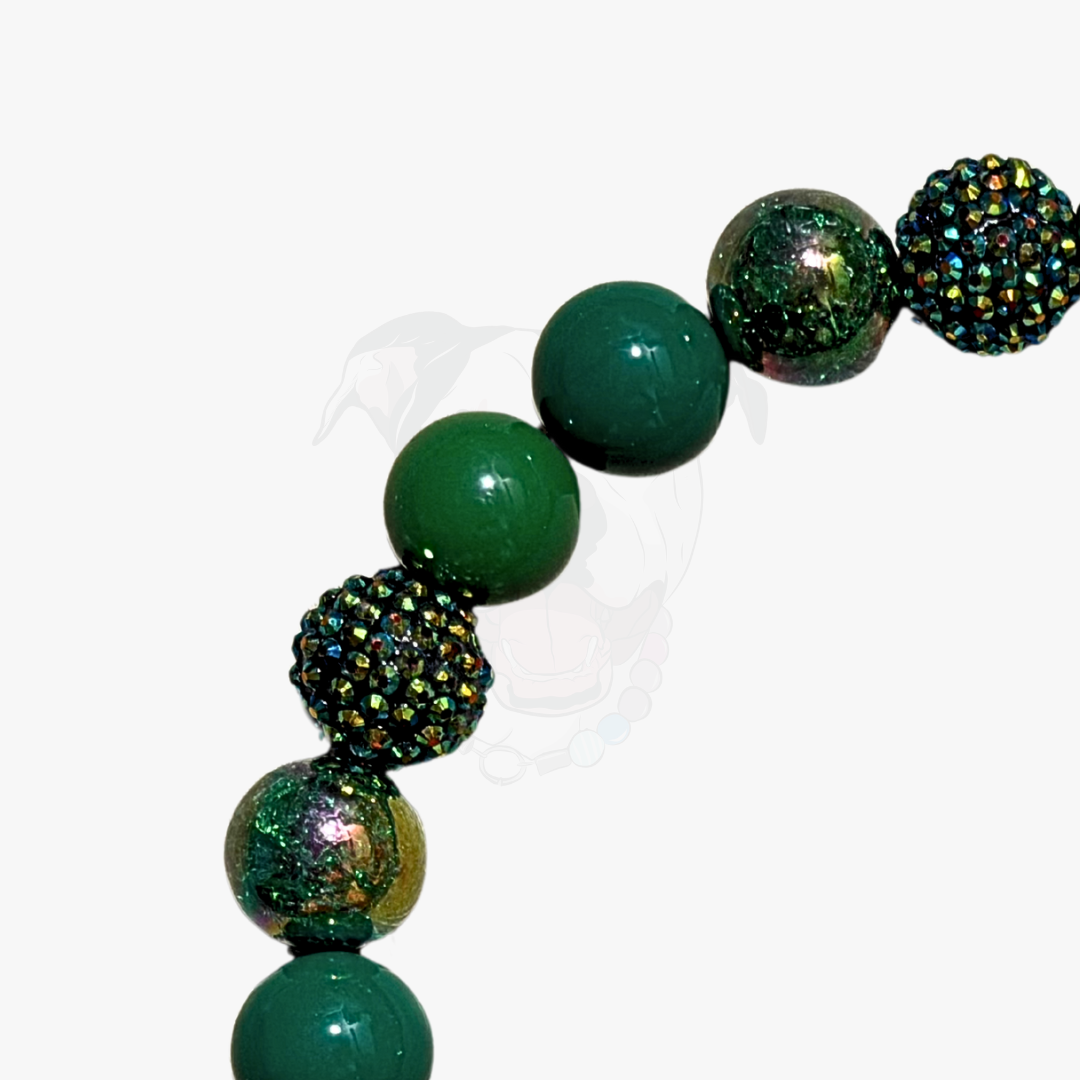 Green beaded bracelet with glittery accents on a white background