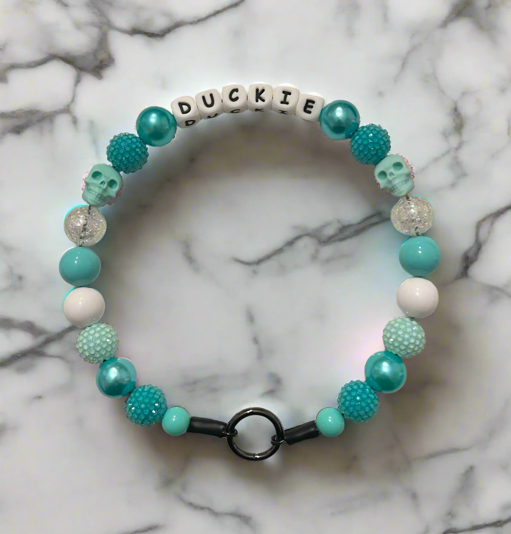 Beaded bracelet with turquoise, white, and green beads on a marble background