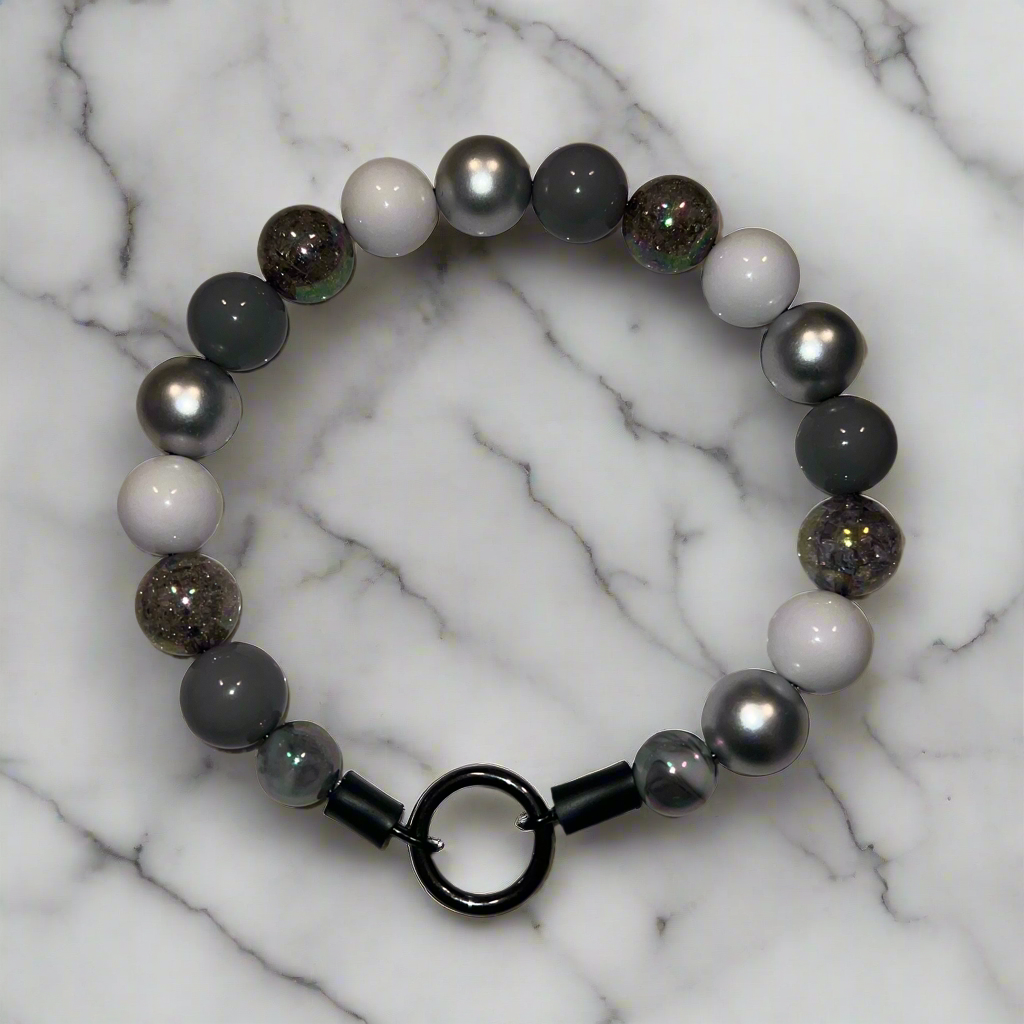 Beaded bracelet with black clasp on a marble background