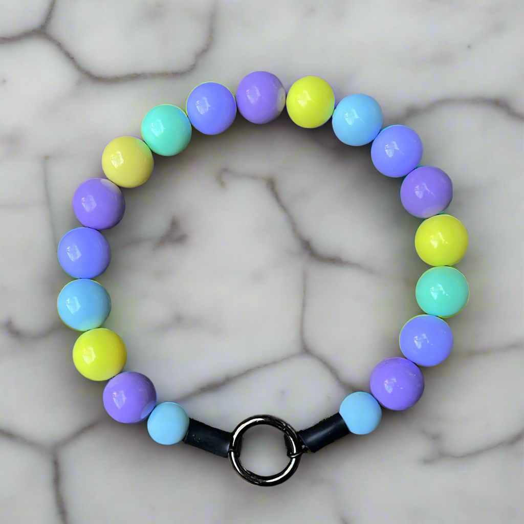 Colorful beaded bracelet with a black clasp on a marble background