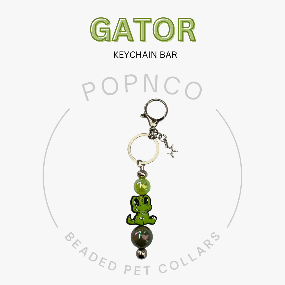 Green gator-shaped keychain bar with beads on a white background, featuring the brand 'Popnco'.