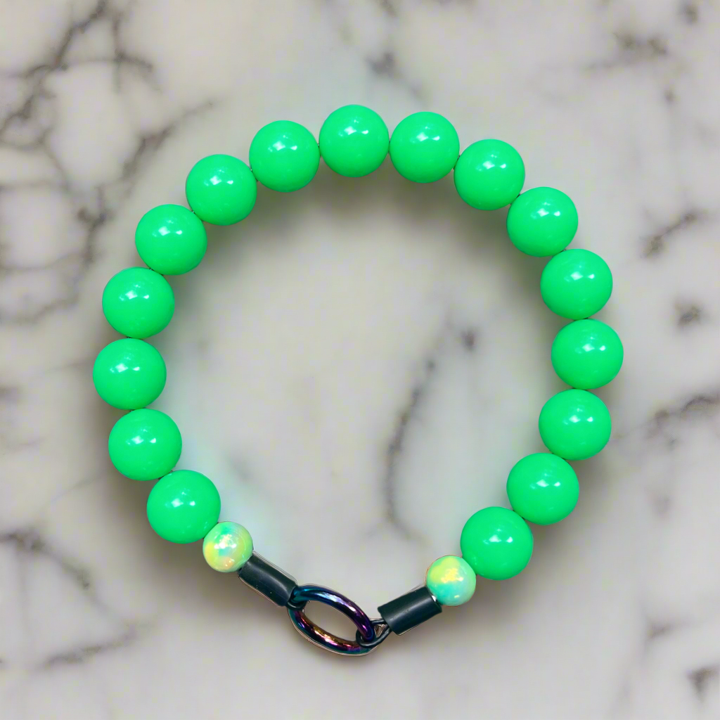 Green beaded bracelet on a marble surface