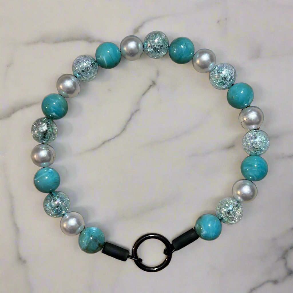 Beaded bracelet with turquoise and silver beads on a marble background