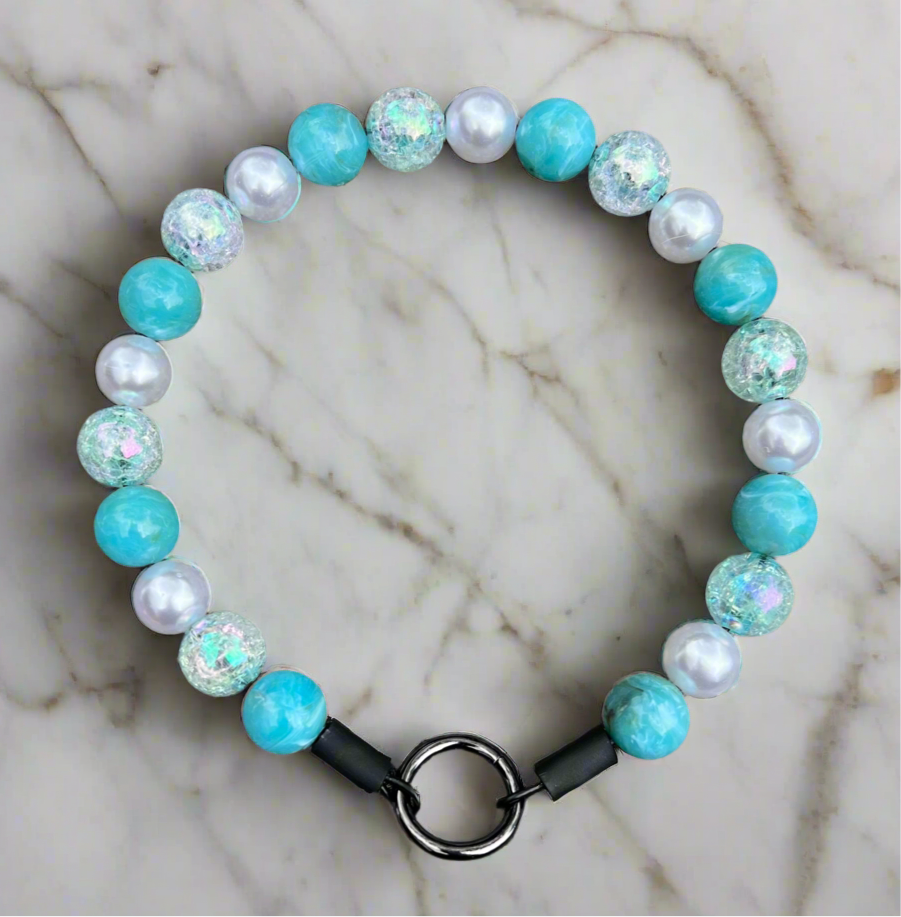 Beaded bracelet with turquoise and white beads on a marble surface
