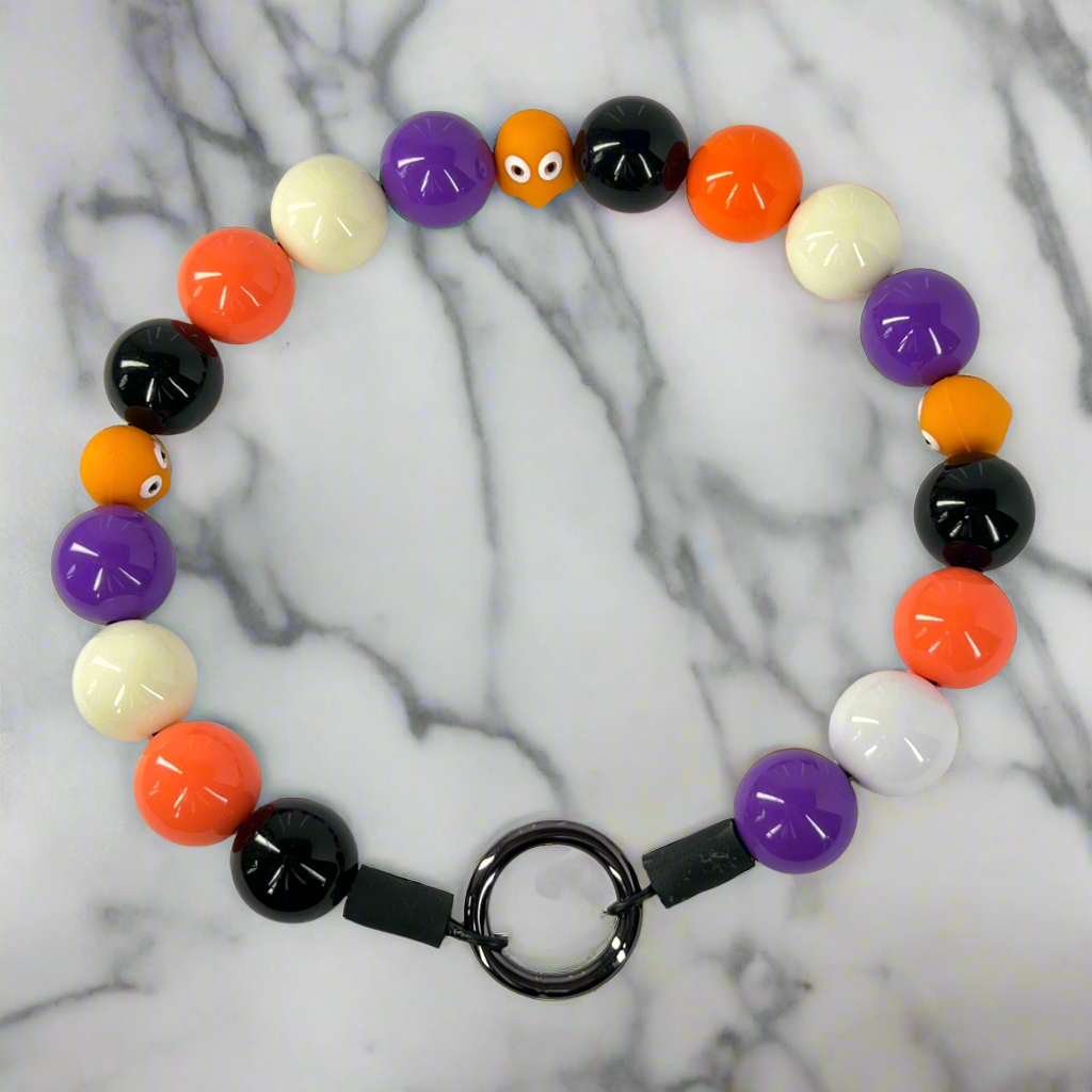 Colorful beaded bracelet with a black clasp on a marble background