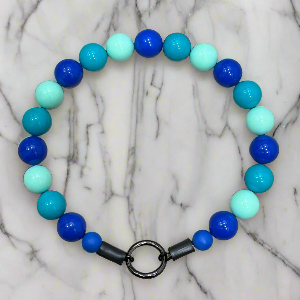 Beaded bracelet with blue and turquoise beads on a marble background