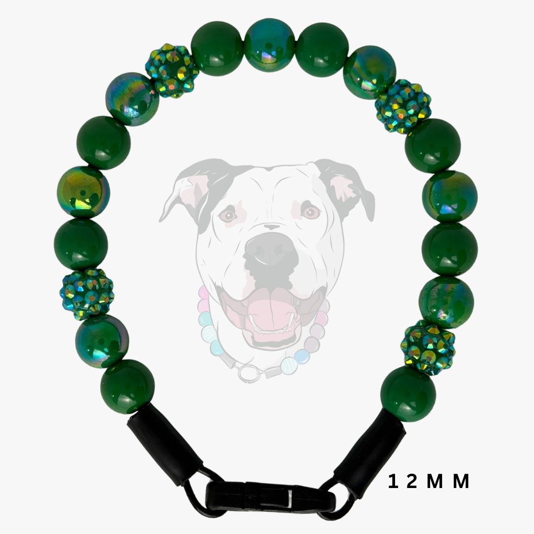 A green beaded dog collar with iridescent green and blue faceted beads and a black clasp, shown against a light gray background with a faint dog graphic and '12 MM' text.