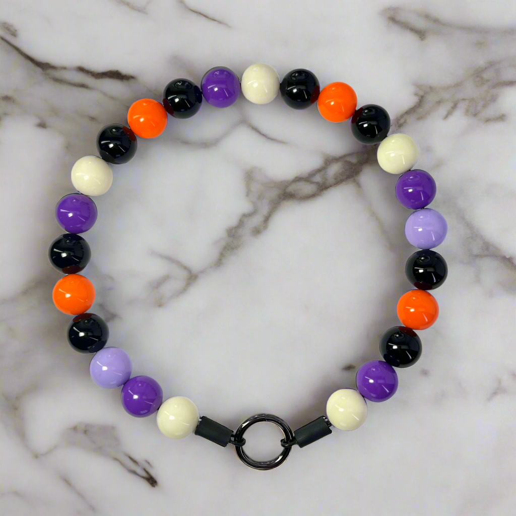 Colorful beaded bracelet with a black clasp on a marble surface
