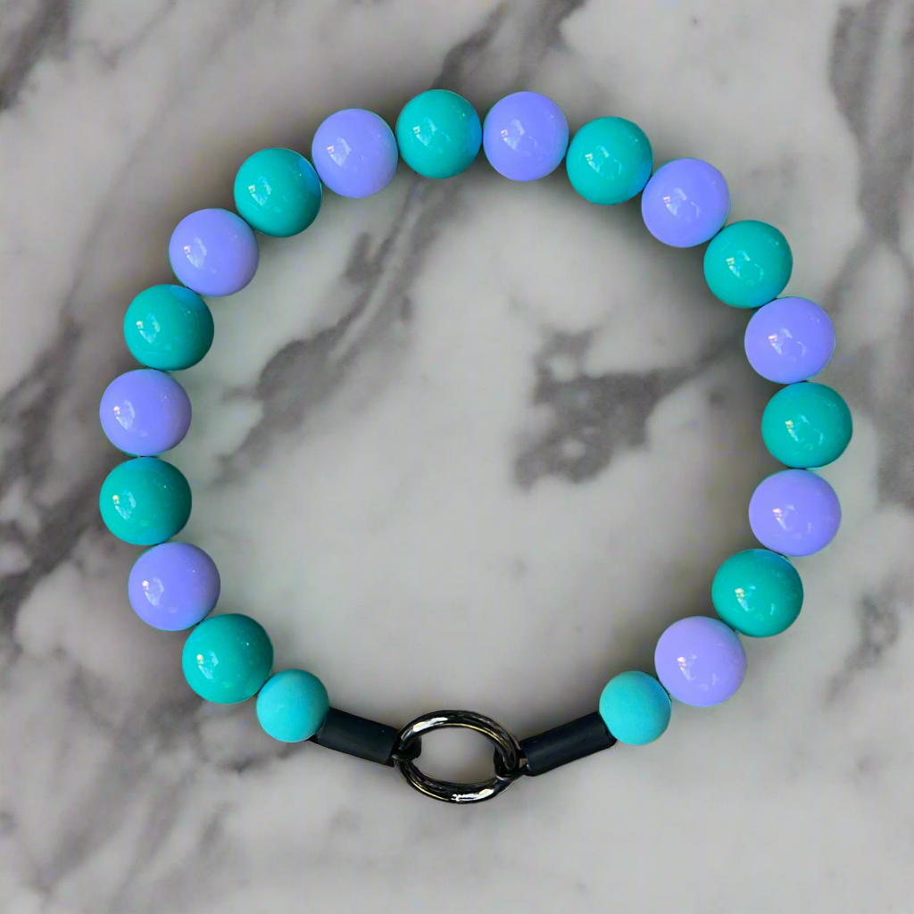 Beaded bracelet with turquoise and purple beads on a marble background