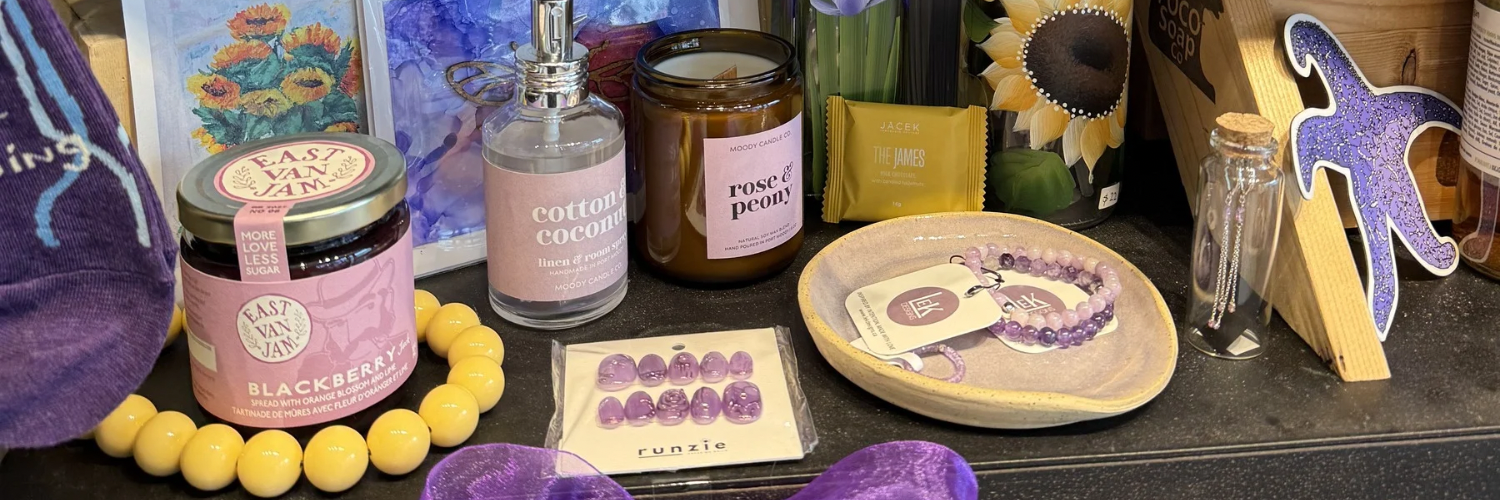 Collection of decorative items including candles, a soap, and a jar on a dark surface.
