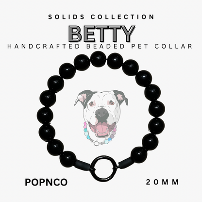 Black beaded pet collar with a dog illustration on a white background, labeled 'BETTY' from the Solids Collection.
