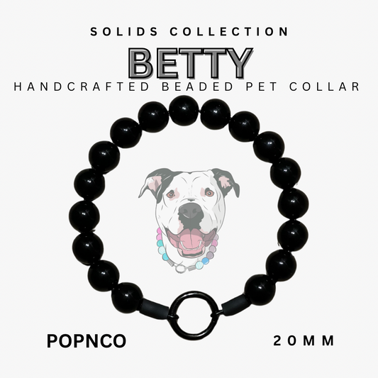 Black beaded pet collar with a dog illustration on a white background, labeled 'BETTY' from the Solids Collection.