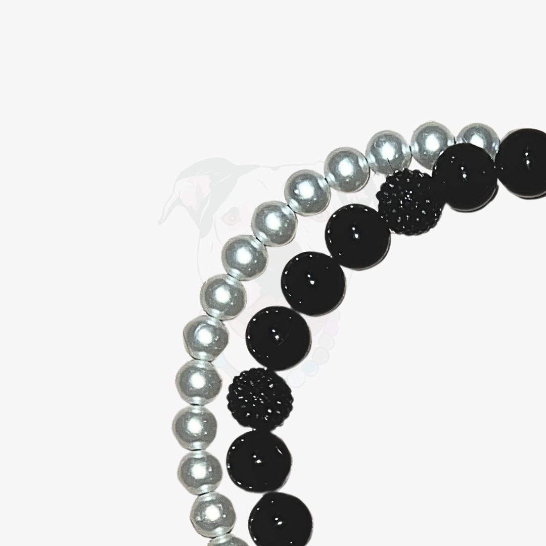 Two beaded bracelets, one with black beads and the other with pearls, on a white background.