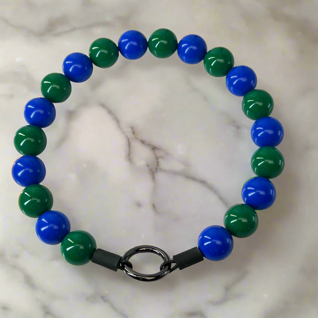 Beaded bracelet with blue and green beads on a marble surface
