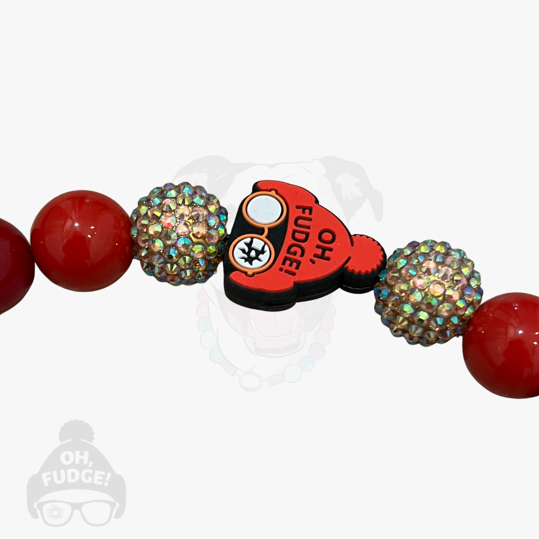 Bracelet with red beads and a heart-shaped charm on a white background