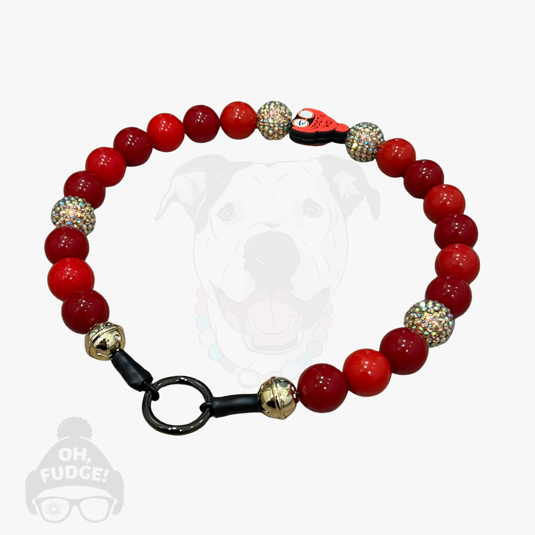 Red beaded bracelet with gold and silver accents on a white background