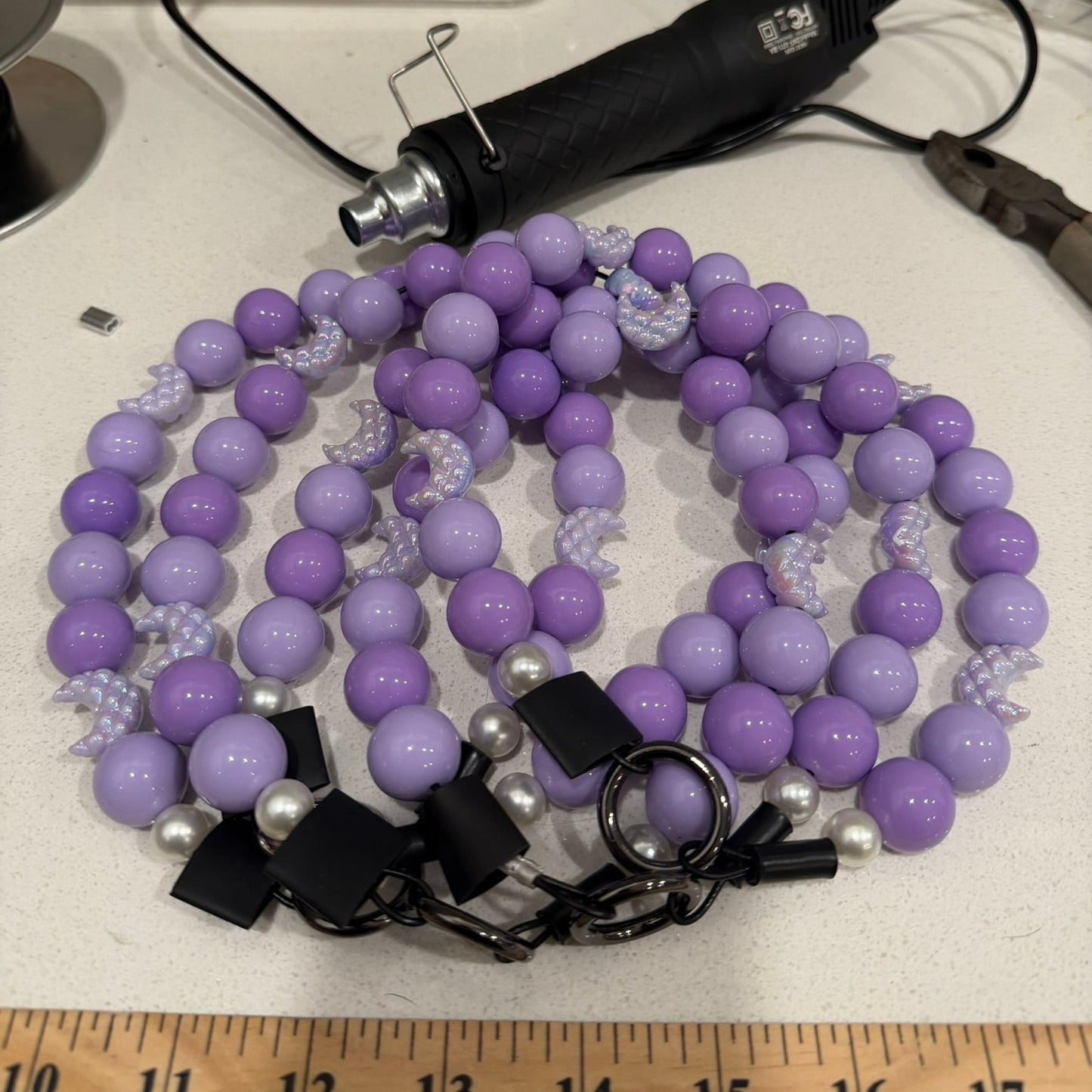 Purple and Moons beaded necklace with clasp on a white surface with a ruler for scale. Behind the Scenes with POPNCO Beaded Pet Collars