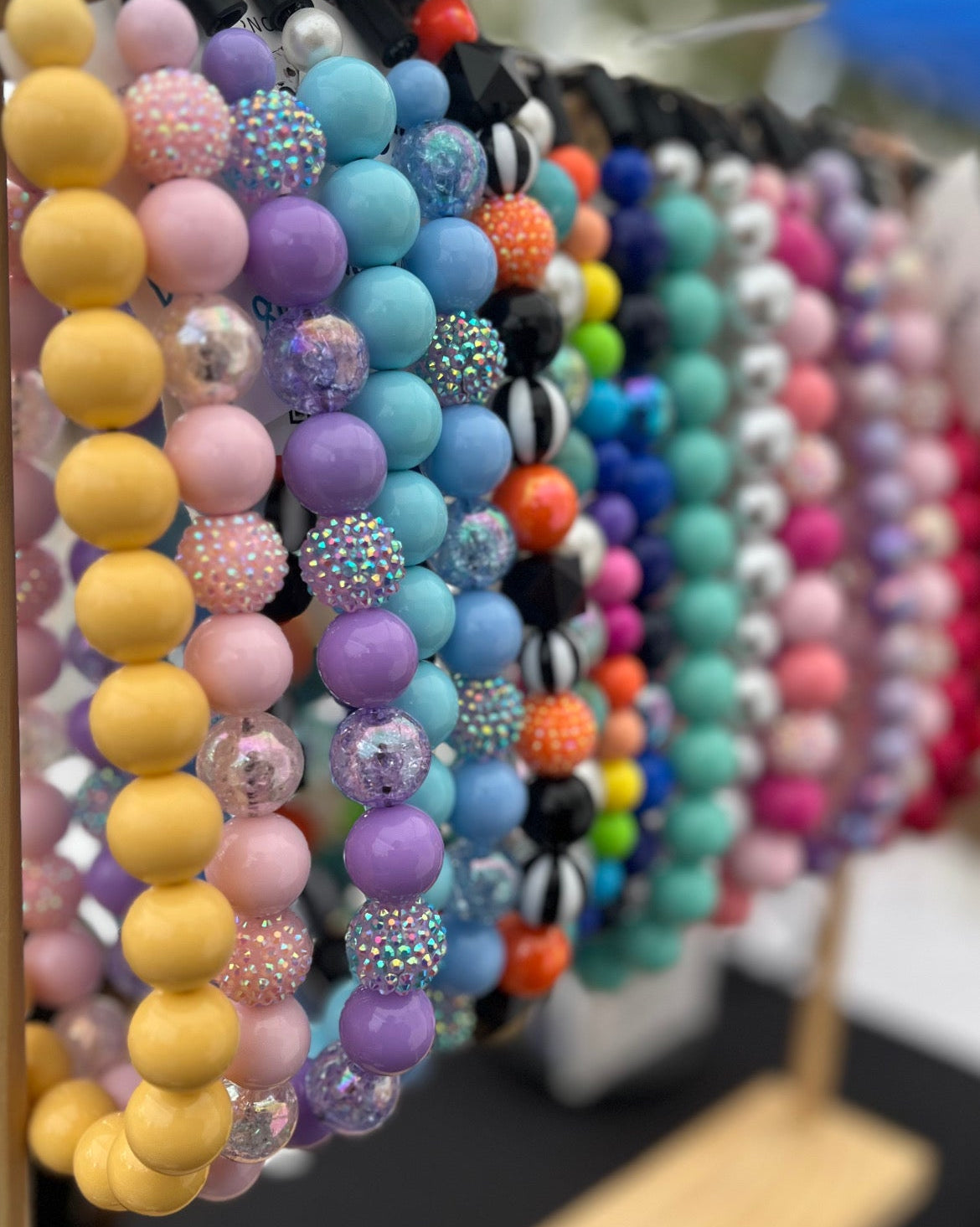 Colorful beaded bracelets on display with a dog emoji and 'coquitlammarket' text.