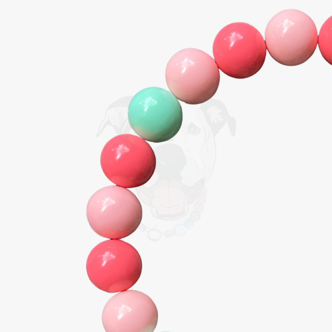 String of pink and green beads on a white background