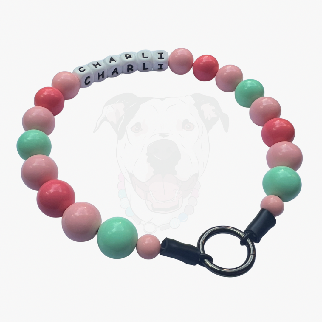 Bracelet with pink and green beads and a black clasp on a white background POPNCO beaded collar, Beaded dog collar, Breathable dog collar, cat collar, Collar for sensitive skin dogs, Comfortable Dog Collar, dog collar, Durable dog collar, Easy to clean dog collar, fashion collar, handmade, Pet accessories, pet collar, Popnco dog collar, slip on collar, Slip on dog collar, Stylish dog collar