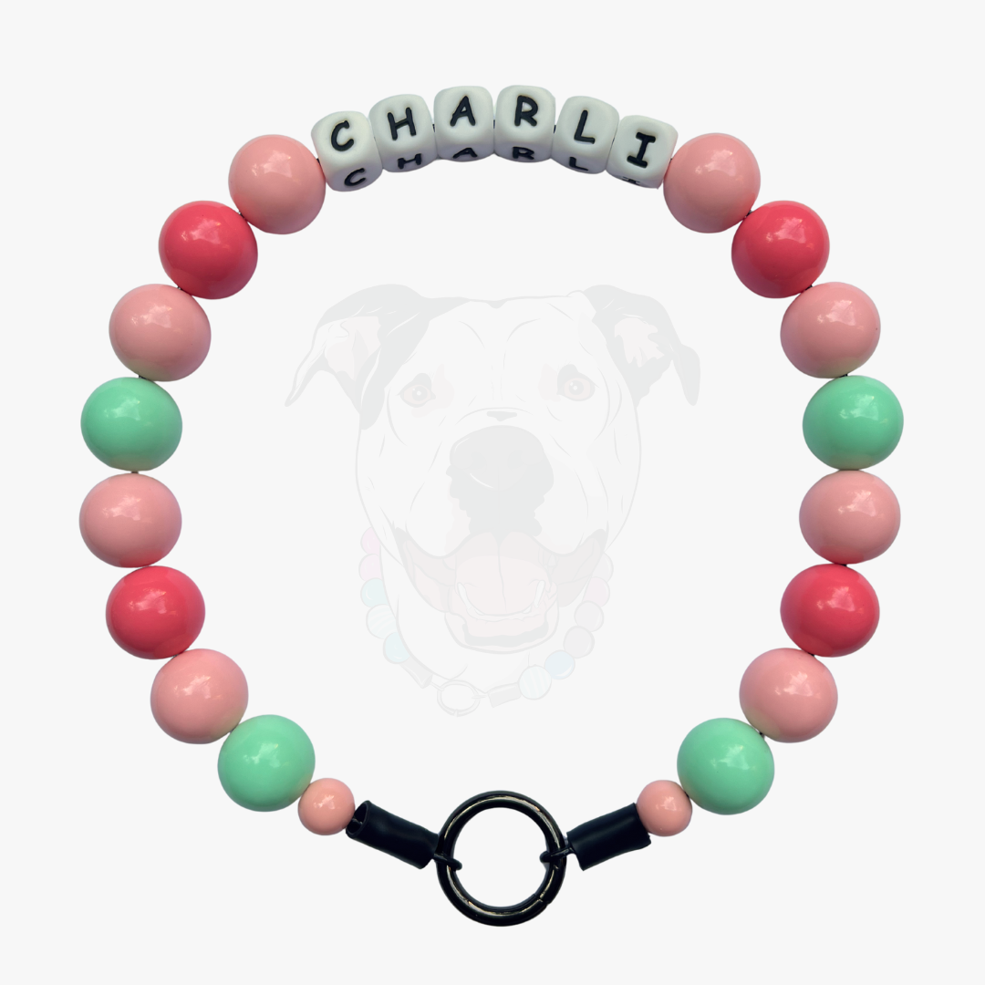 Bracelet with pink and green beads and a name tag on a white background