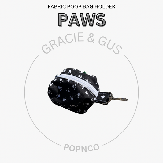 Fabric poop bag holder with 'PAWS' branding on a white background