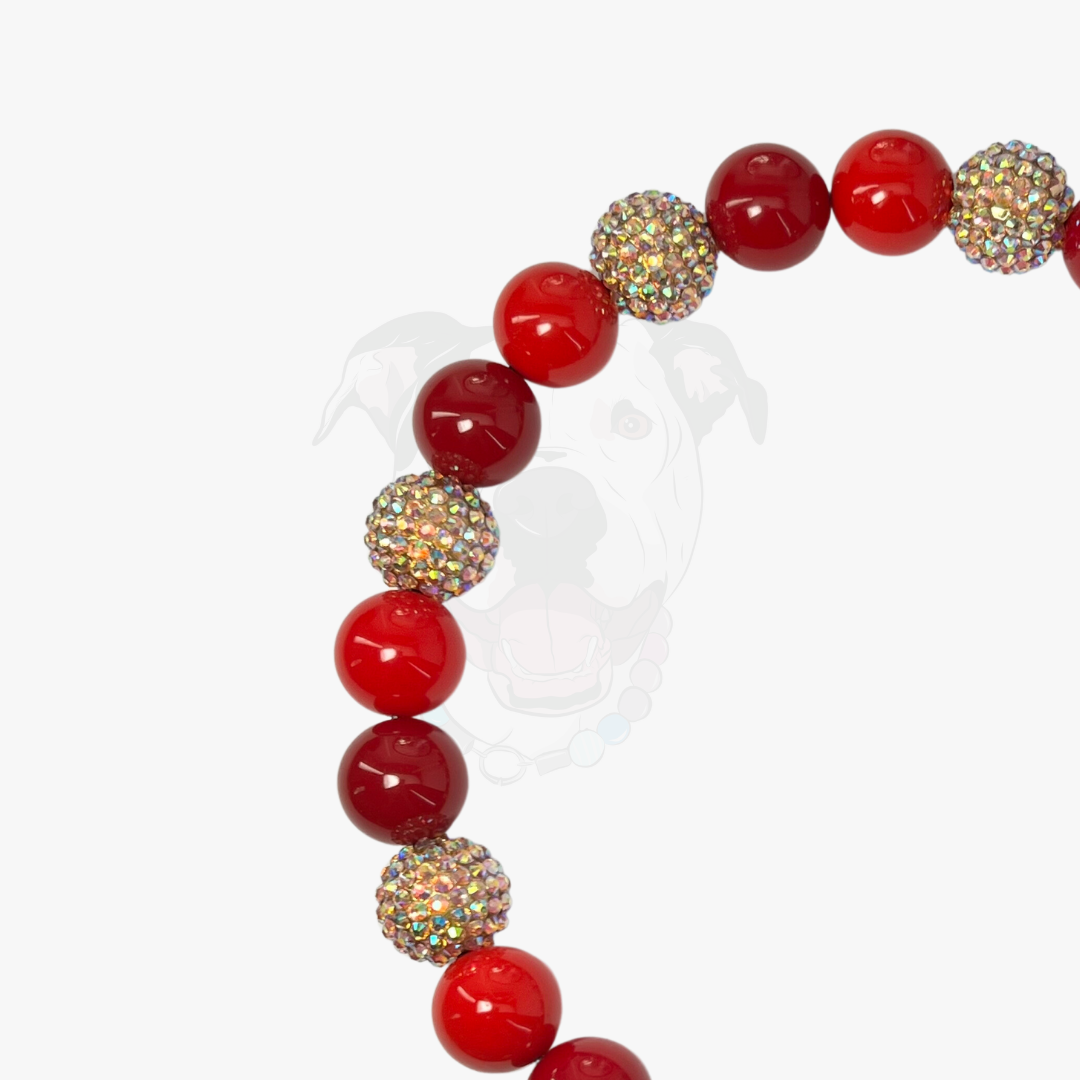 Bracelet with red beads and gold accents on a white background