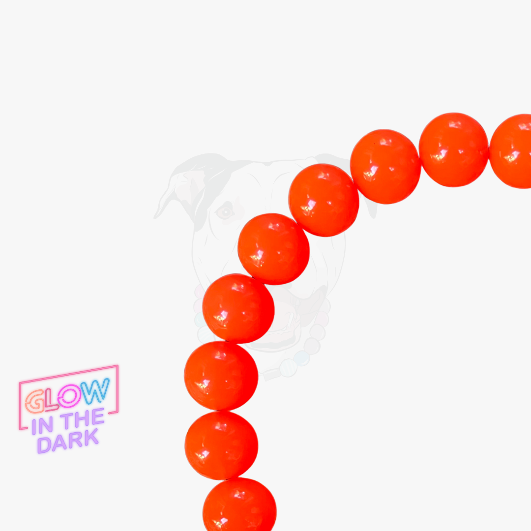 Orange glow-in-the-dark beads arranged in a heart shape on a white background with 'Glow in the Dark' text.