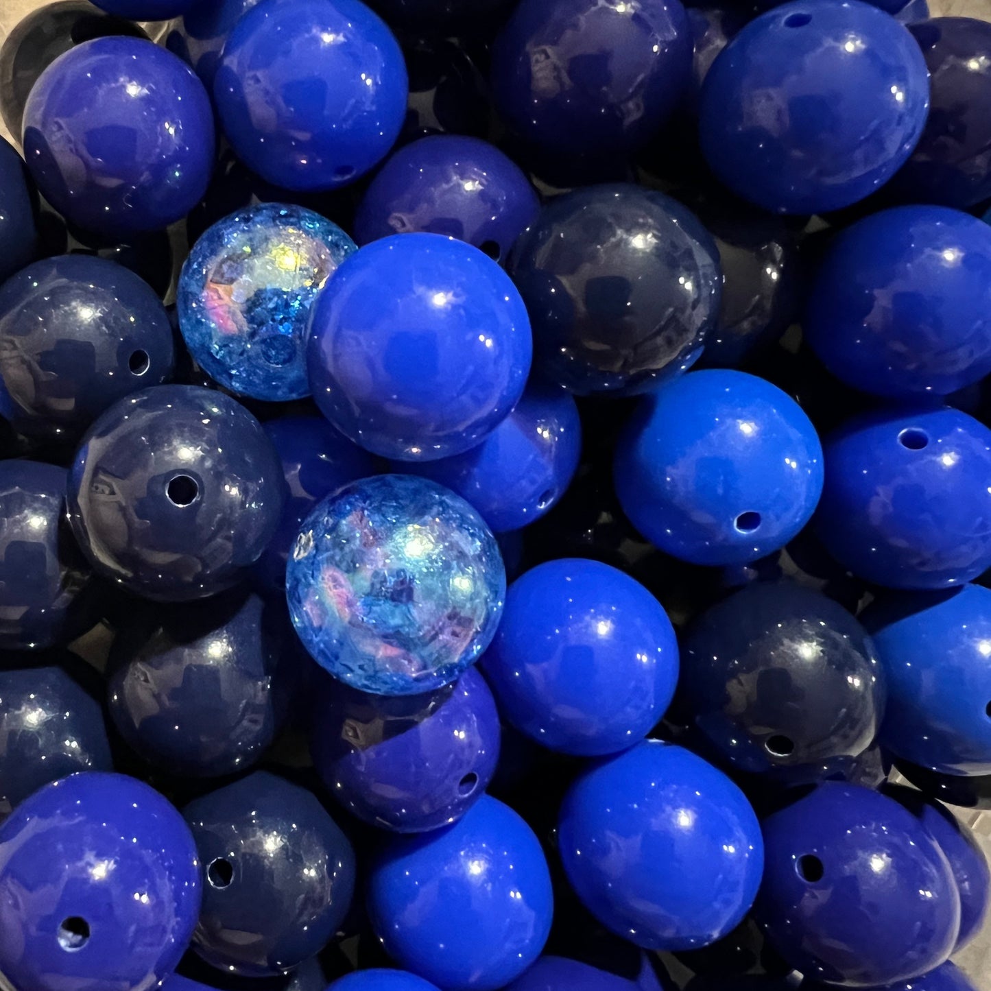 Close-up of blue beads with a glossy finish POPNCO beaded collar they are used in The indigo blue beaded pet collar featuring alternating royal blue, dark blue and navy blue solid beads mixed with blue crackle beads in 20mm