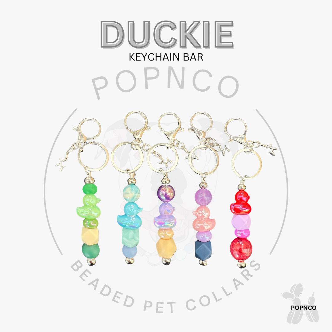 Colorful beaded keychains on a white background with 'Duckie' and 'Popnco' branding.