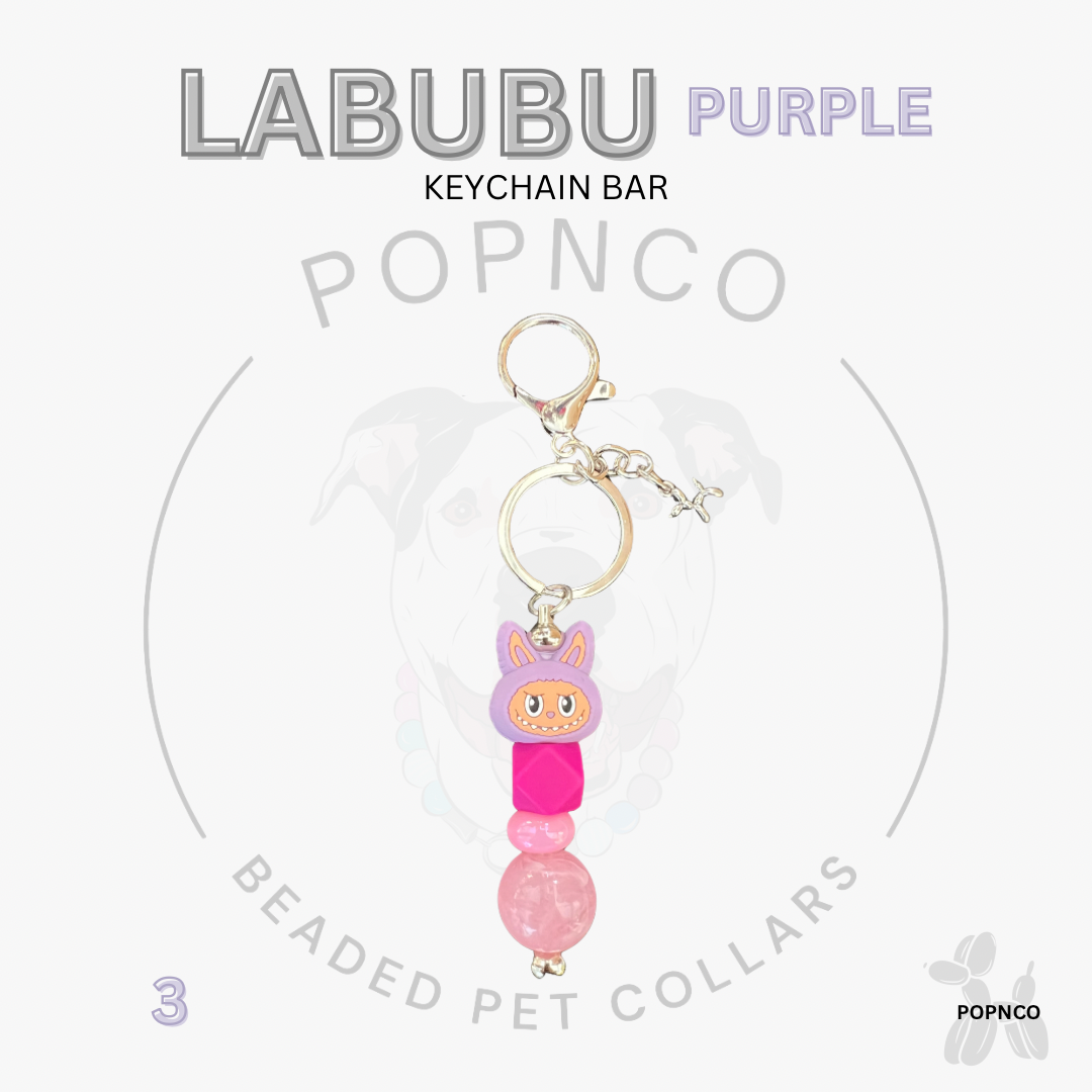 Purple beaded keychain bar with a cartoon character on a white background, featuring the brand 'LABUBU' and 'POPNCO'.