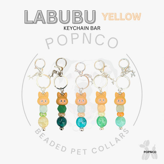 Labubu yellow keychain bar with beaded pet collars on a white background