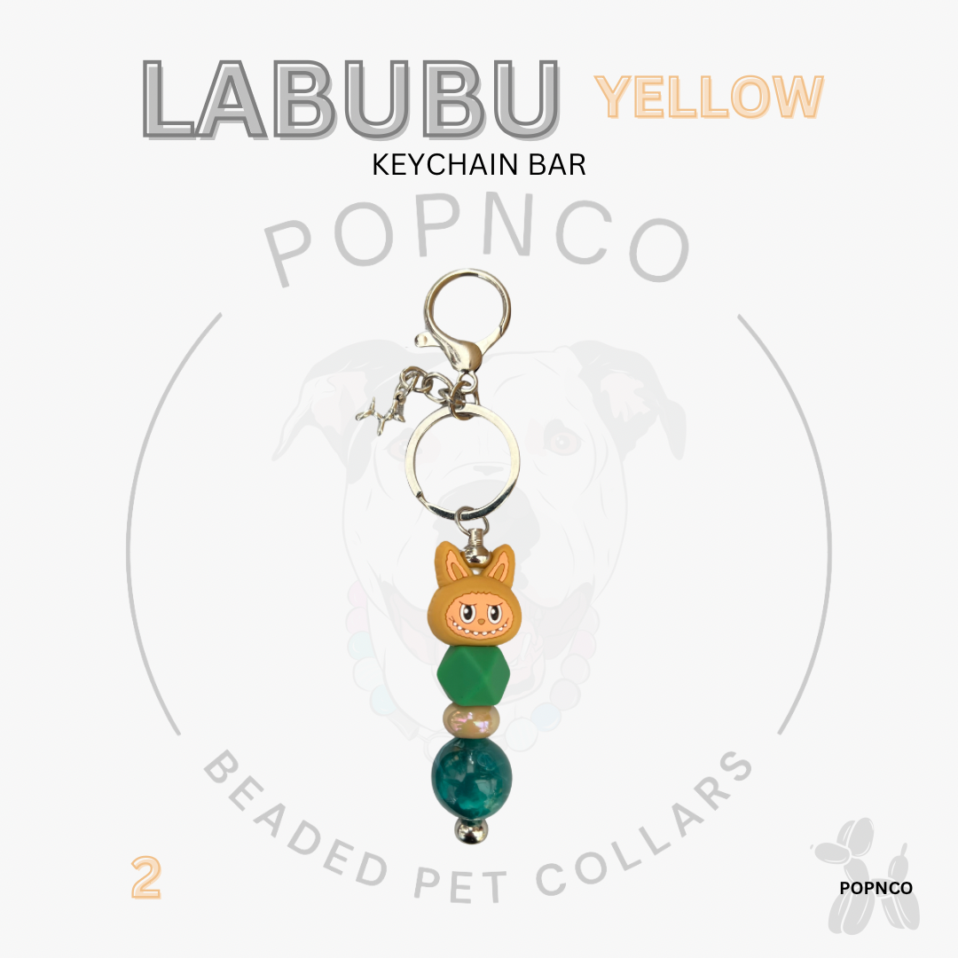 Yellow keychain bar with cat-shaped charm and beads on a white background, featuring 'LABUBU' and 'POPNCO' branding.