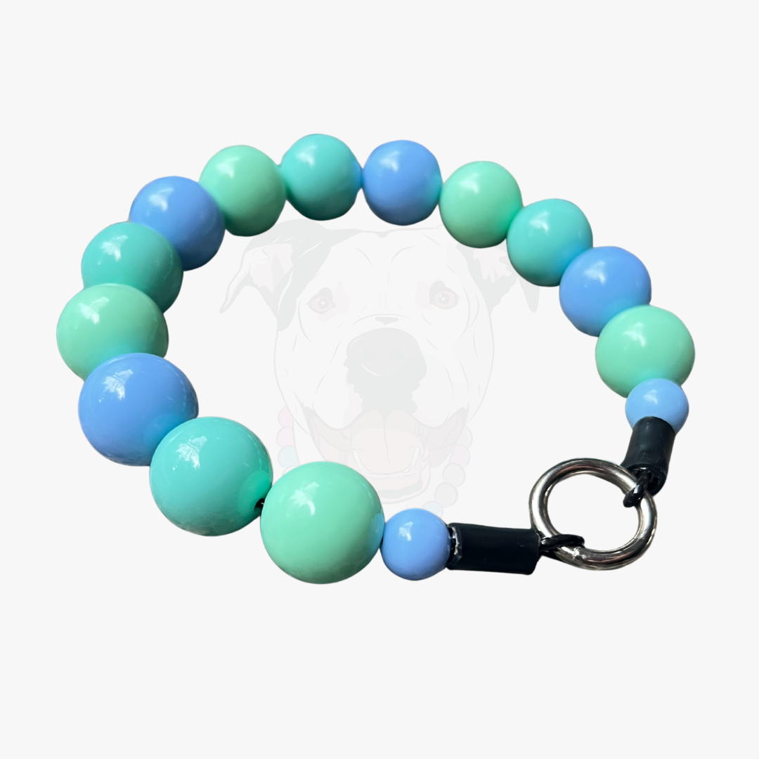 Bracelet with blue and green beads and a keychain attachment on a white background