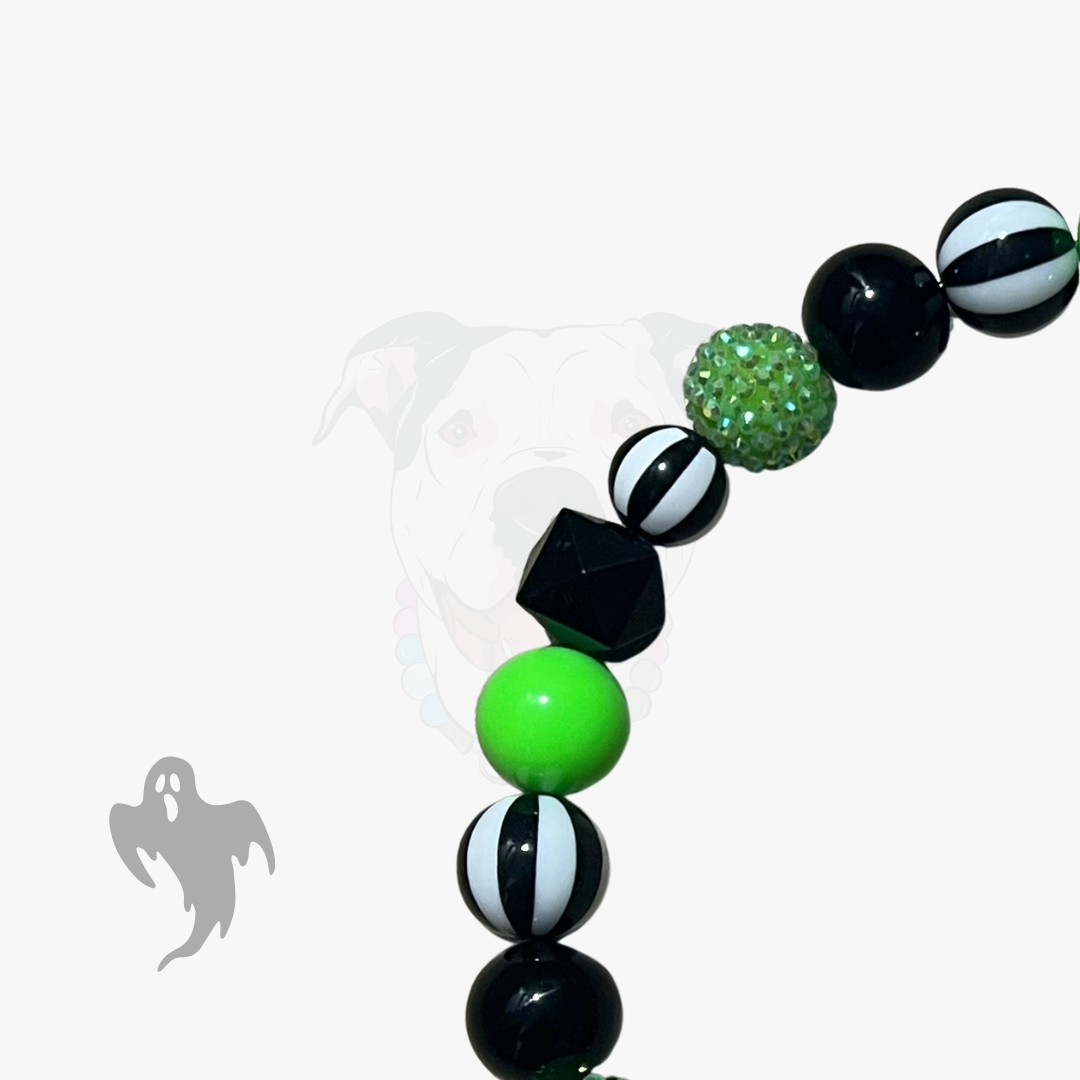 Bracelet with green, black, and white beads on a white background