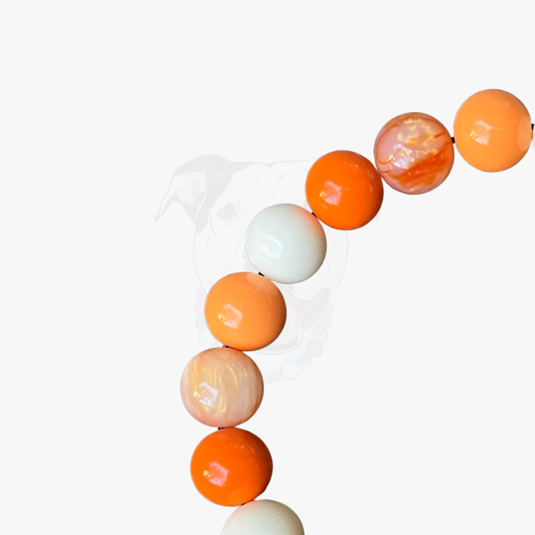 Neon orange and white round beads on a white background