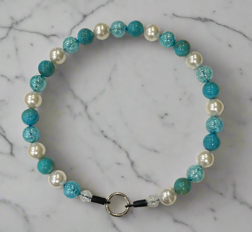 Beaded bracelet with turquoise and white pearls on a marble background