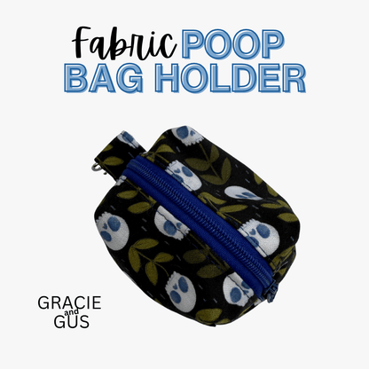 A fabric poop bag holder pouch with a black background, white and blue skull pattern, and olive green leaves, featuring a blue zipper. The text 'Fabric POOP BAG HOLDER' is displayed at the top, and 'GRACIE and GUS' is displayed at the bottom left, all on a light gray background.