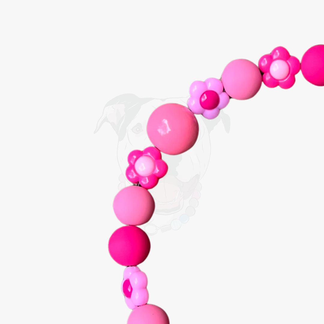 Pink beaded bracelet with flower-shaped beads on a white background