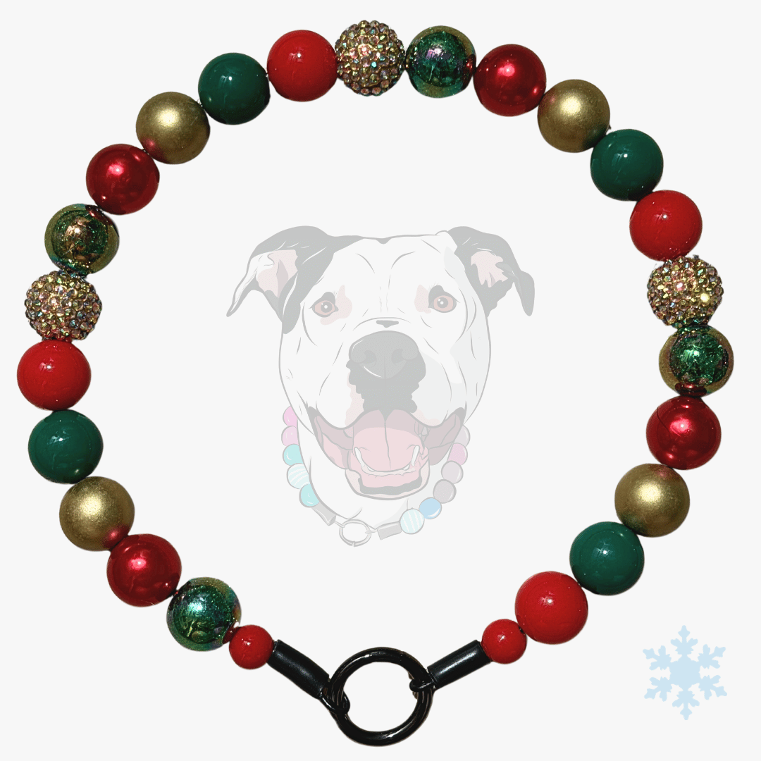 A festive Christmas-themed beaded collar for dogs, featuring red, green, and metallic gold beads, including textured glittery gold and dark green marbled beads. The collar is displayed on a light gray background with a faint graphic of a dog's face wearing the collar, and a black metal clasp is visible at the bottom.