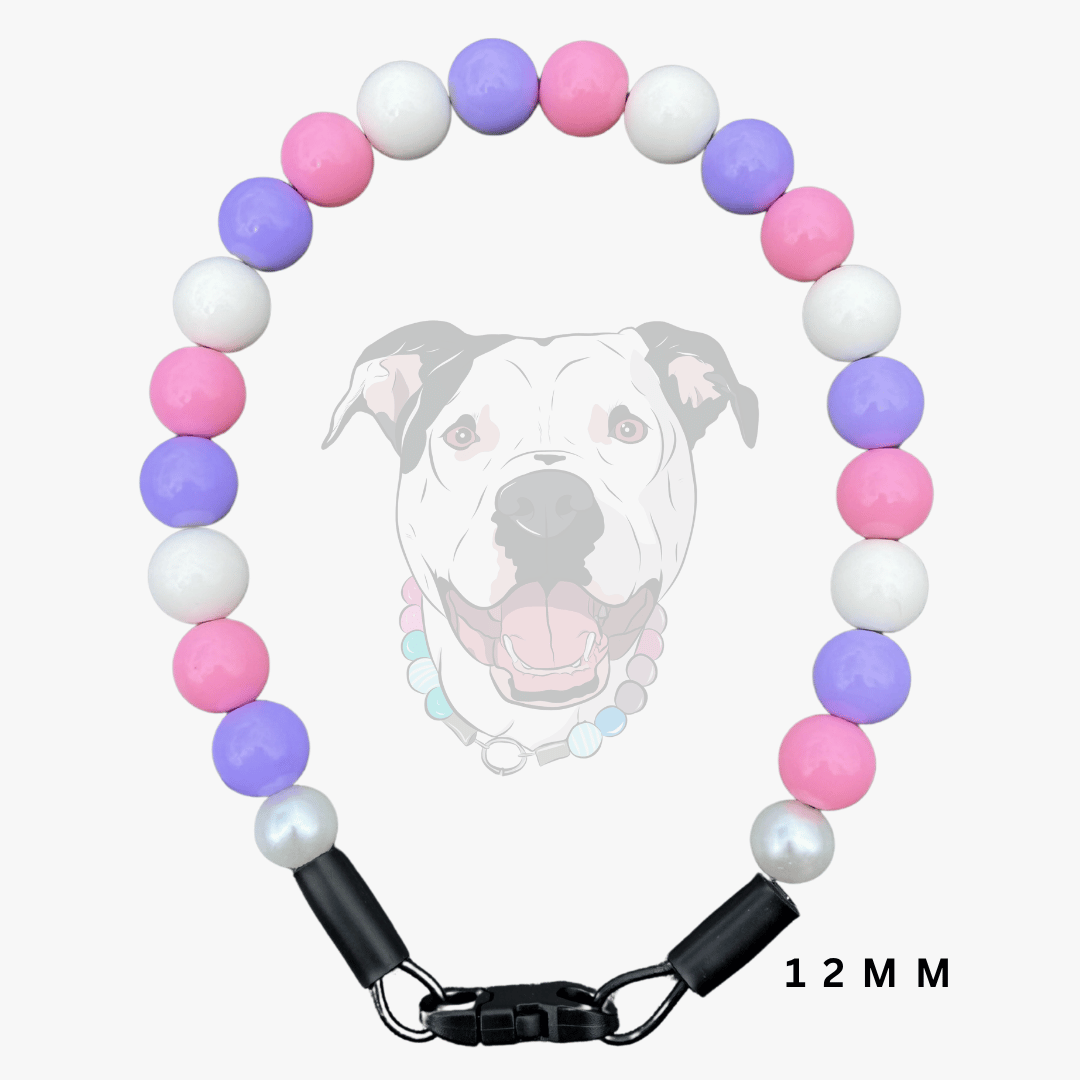 A beaded dog collar with alternating pink, purple, and white round beads, finished with black hardware and a black-and-white graphic of a dog's face in the background.