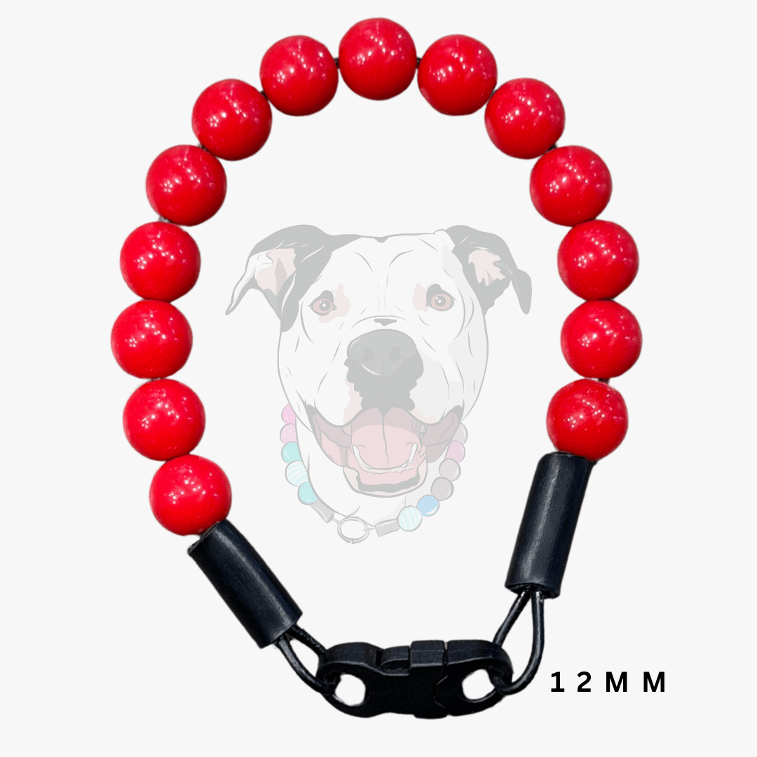 A red beaded dog collar with glossy round red beads, black plastic end caps, and a black quick-release clasp, shown on a light gray background with a faint dog illustration and '12 MM' text.