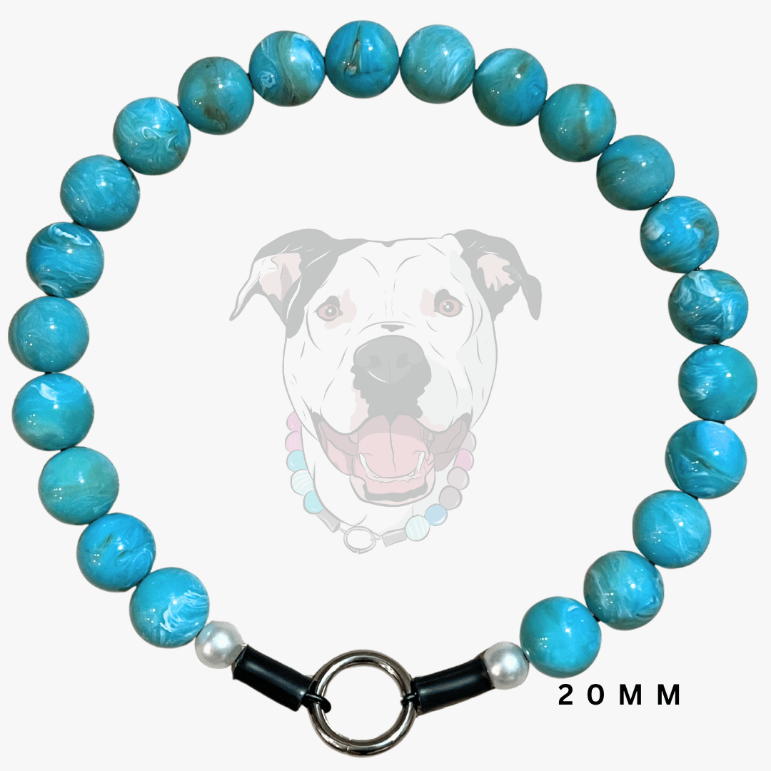 A beaded dog collar made of round turquoise-blue marbled beads, featuring a black toggle clasp with white pearl-like accents and a silver ring. A faint graphic of a dog wearing the collar is in the background, with '20MM' text in the lower right corner.
