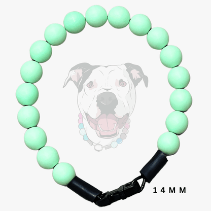 A beaded dog collar made of matte mint green round beads with black leather-like end sections and a black clasp, shown on a light gray background with a faint dog illustration and the text '14 MM'.