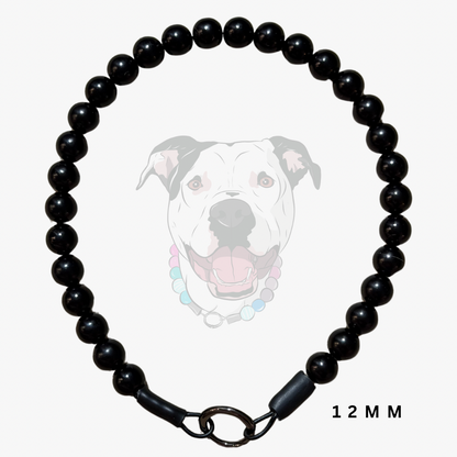 A black beaded dog collar with a clasp closure, shown against a light gray background with a faded graphic of a dog wearing a similar collar and the text '12 MM' in the lower right.