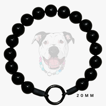 A black beaded dog collar with a large circular ring clasp, shown against a light gray background with a faded graphic of a dog wearing a beaded collar and the text '20MM'.