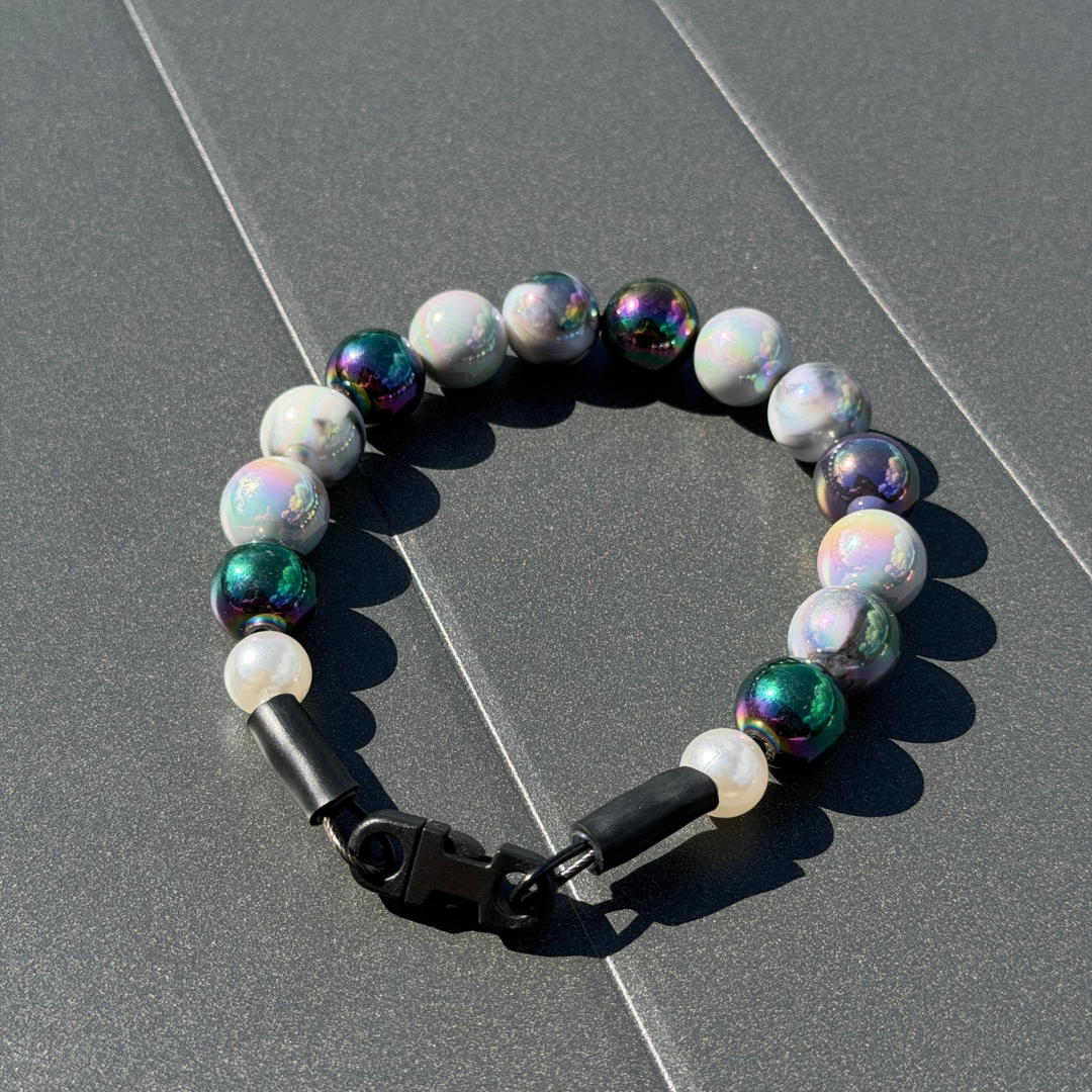 POPNCO Ciara 16mm Beaded Pet Collar. Black, White and Grey AB Shiny Acrylic and Resin Beads on Aircraft Grade Stainless Steel Wire. POPNCO Grey and Black Shiny Beaded Pet Collar laying on a grey table