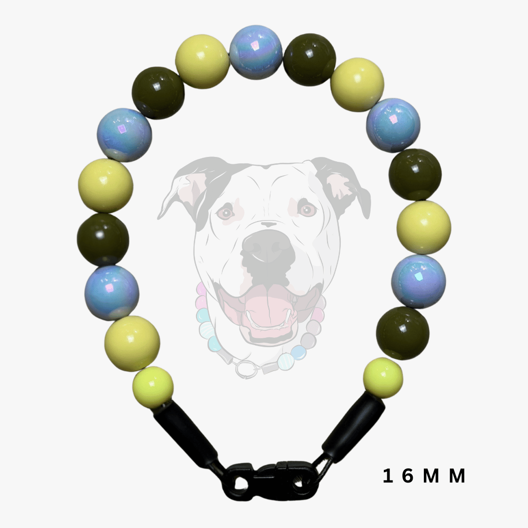 A beaded dog collar with round beads in light blue, pale yellow, and olive green, featuring black plastic clasp connectors and a black-and-white graphic of a dog on a light gray background. The text '16 MM' is visible in the bottom right corner.