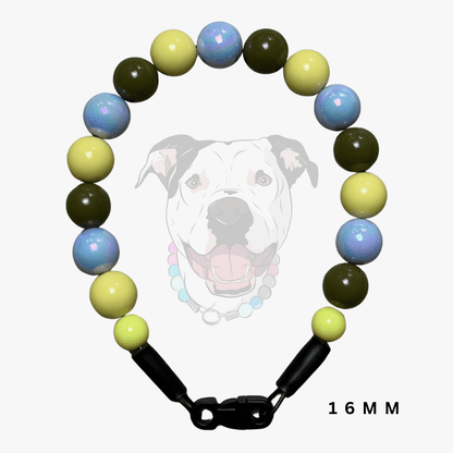 A beaded dog collar with round beads in light blue, pale yellow, and olive green, featuring black plastic clasp connectors and a black-and-white graphic of a dog on a light gray background. The text '16 MM' is visible in the bottom right corner.